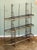 A large French baker's rack or boulangerie display stand of wrought iron with decorative brass trim and finials, featuring...