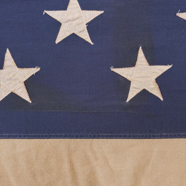 This oversize vintage American flag is made from a cotton cloth, with fully sewn stars and stripes. Flag has been...