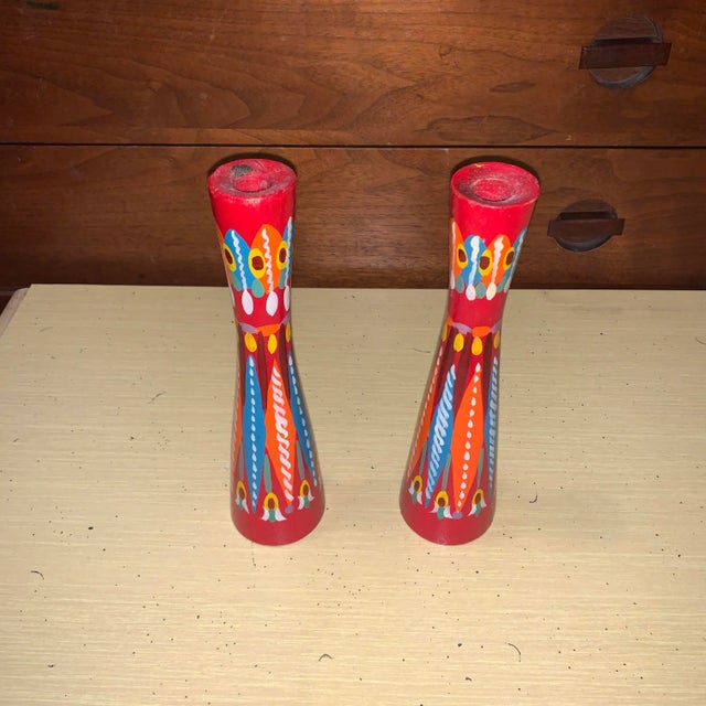 A pair of multicolored candlesticks with blue, green, orange, white, yellow, purple and red. Possibly Mexican.