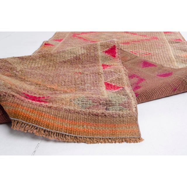 This is a vintage Turkish Oushak rug from the Mid 20th Century. The piece was hand-knotted.