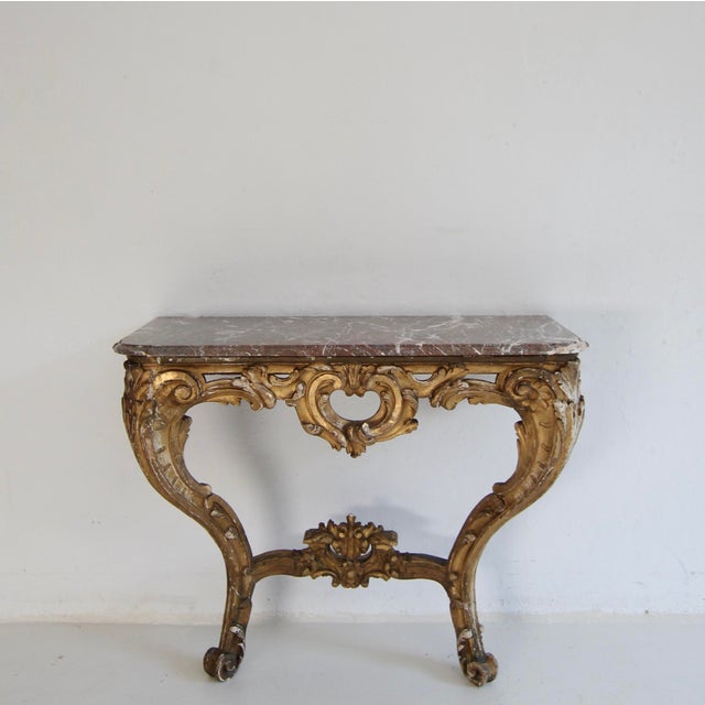 A 19th century Louis XV style wall console table with marble top. Probably from the Napoleon III epoch. Gesso and gold...