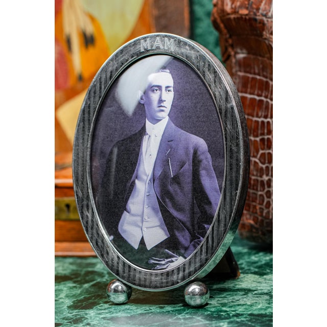 A refined example of early 20th-century silver craftsmanship, this large sterling silver picture frame beautifully...