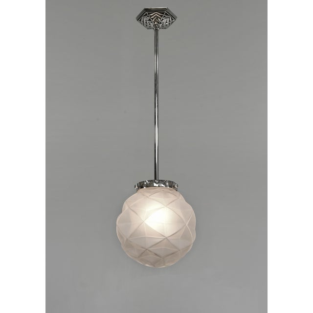 Degué A French 1925-1935 art deco pendant light in nickel plated bronze. The mounting holds a nice ball shaped shade in...