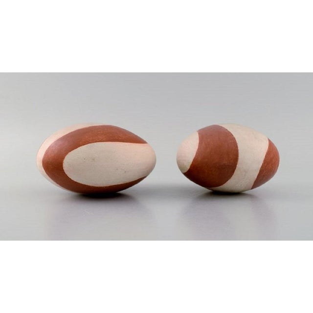 European studio ceramicist. Two rattle instruments in glazed stoneware. Hand-painted wavy decoration in orange-brown...