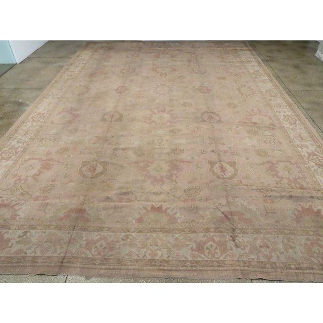 An antique Turkish Oushak oversize carpet. This Turkish town carpet has a five-column pattern derived from the classic...