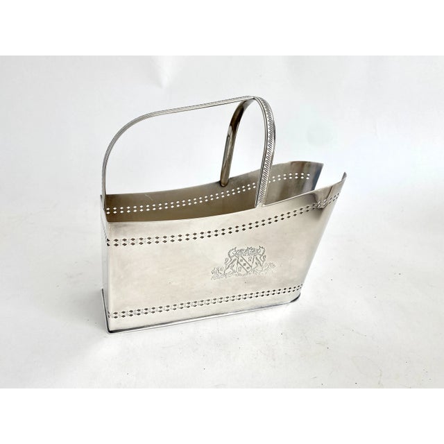 English Barker-Ellis silverplate wine pourer with pierced detail and an ornate emblem.