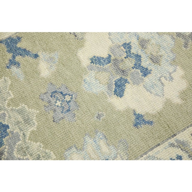 This modern Turkish Oushak rug is a stunning piece of art that has been handwoven using traditional techniques by skilled...