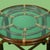 Round rattan side table with an intricately pierced fretwork base and a glass top. The openwork rattan pedestal creates...