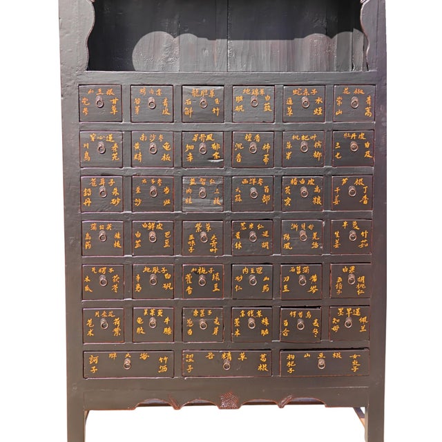 This antique apothecary cabinet, made from solid elm, features a striking black lacquer finish. The upper section includes...
