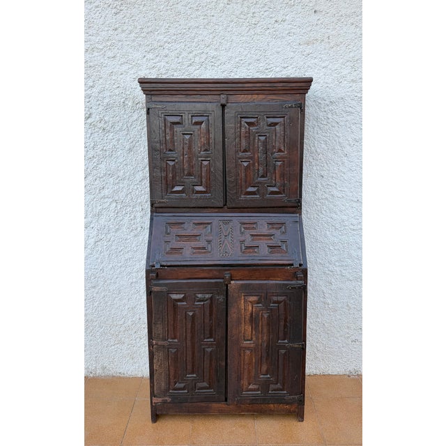 Impressive antique Spanish bureau cabinet dating from the 19th century, crafted in wood and featuring richly carved...
