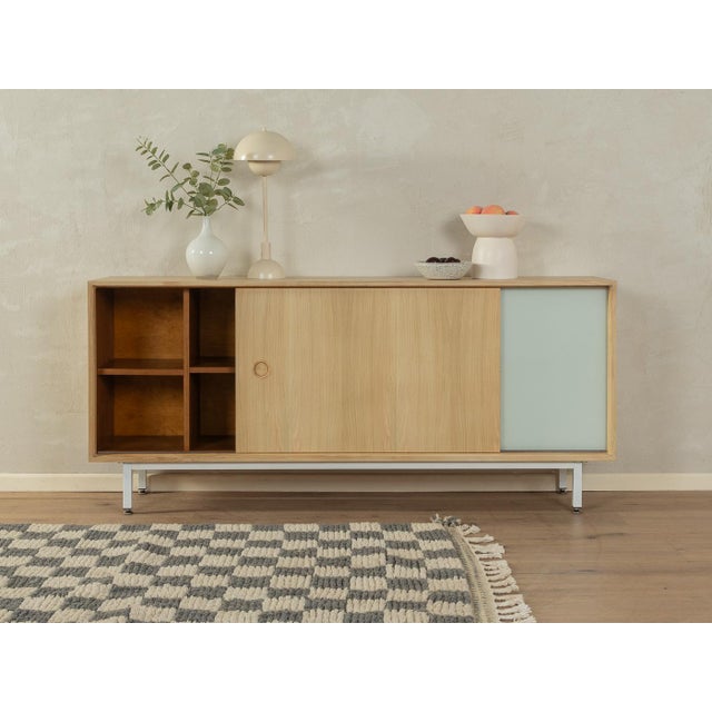 Wonderful sideboard from the 1960s. Corpus in bleached walnut veneer with one wooden sliding door, one glass sliding door...