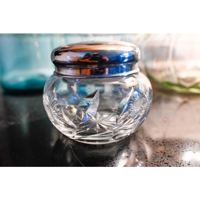 A round antique cut glass dresser/vanity jar in the American Brilliant Period style (roughly 1900s–1920s), with deep-cut...