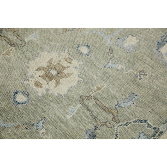 This modern Turkish Oushak rug is a stunning piece of art that has been handwoven using traditional techniques by skilled...