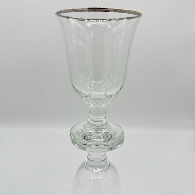 A beautiful set of four vintage clear glass wine goblets featuring gracefully flared bowls, substantial short stems and...