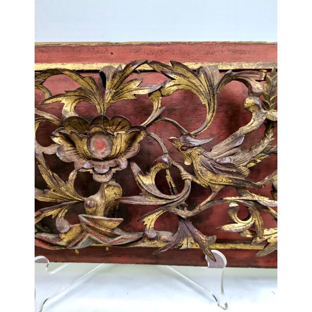 A beautiful wooden panel of 2 birds looking towards a large flower. This has been intricately carved with intertwining leaves