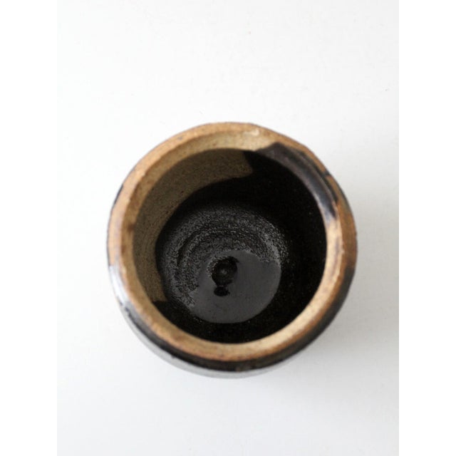 A vintage handmade studio pottery vase. This sculptural studio pottery vase features a softly rounded form with a richly...