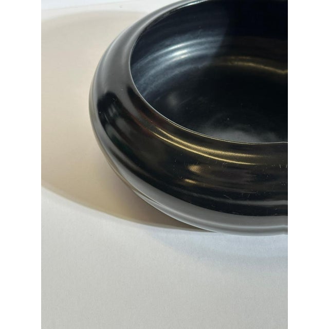 This stoneware bowl by Doulton Lambeth, produced in England circa the 1930s, reflects a restrained Art Deco aesthetic...