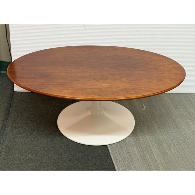 Design Plus Gallery presents a Tulip Base Coffee Table. The two tone coffee table has a walnut wood oval surface with a...