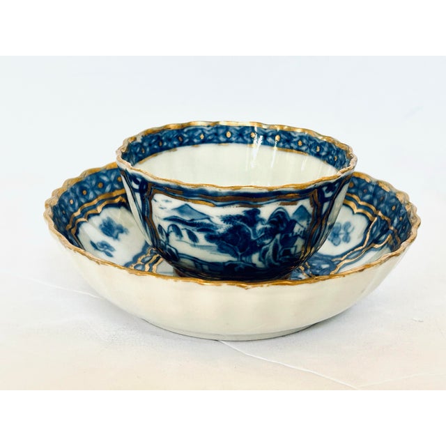 Chinese export porcelain tea bowl and saucer set from the Qianlong period (1736–1795) featuring underglaze blue landscape...