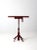 This is a vintage industrial table. The pedestal work table features a red metal base with wooden top.