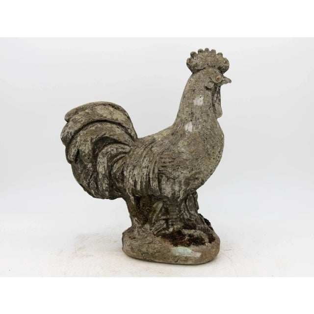 This iconic French Country rooster sculpture, fashioned from aged concrete, exudes rustic elegance and timeless allure....