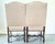 A handsome pair of French fruitwood armchairs featuring gracefully scrolled arms, shaped stretchers, and elegantly carved...