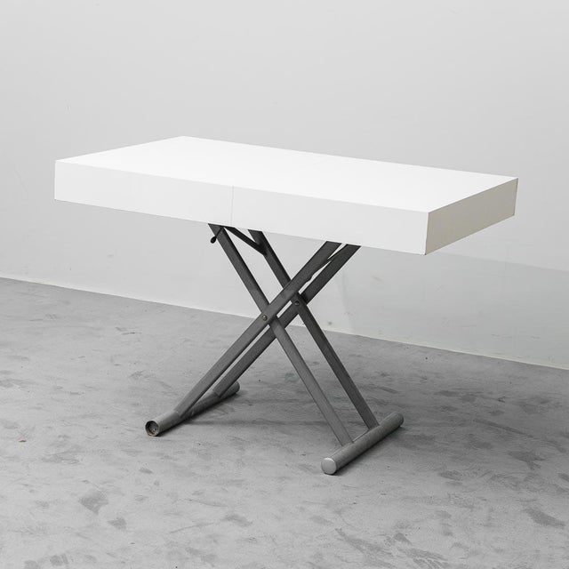 Coffee table that converts to an extendable dining table. Metal legs with a white lacquered wooden top. Good condition,...