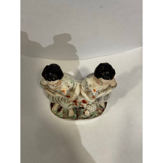 This is an antique Victorian Staffordshire figurine depicting children holding Lambs. It has hand painted polychrome...