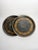 Pair of hand-painted, circular black trays adorned with a gilt floral frieze. The deep black background highlights the...