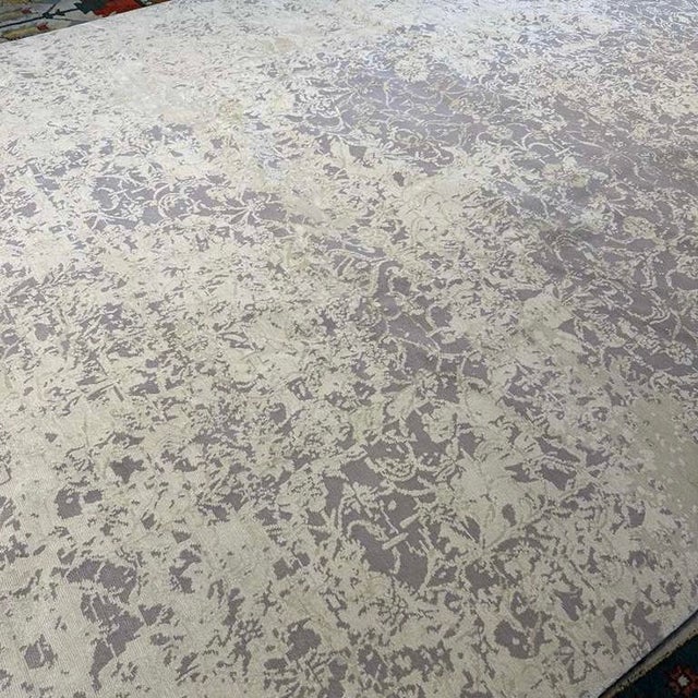 This elegant 10' x 14' rug, hand-knotted in Nepal, features a modern abstract design rendered in beautifully textured...