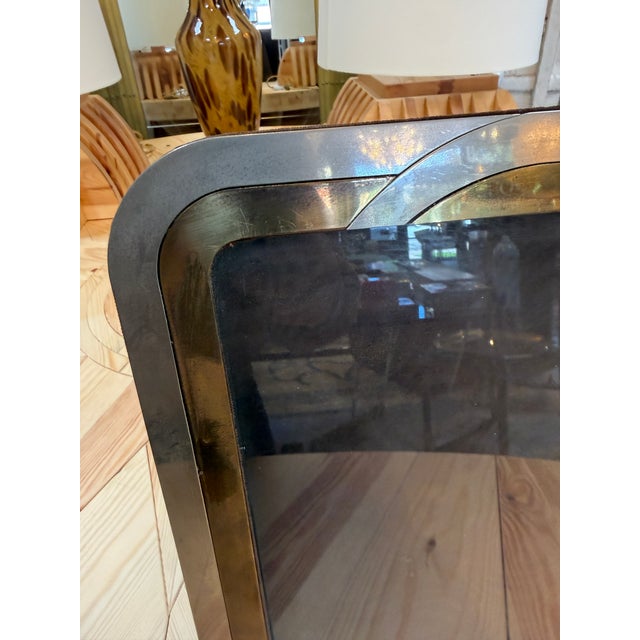 A vintage picture frame with rounded corners and overlapping silver and brass tone bands. The layered design gives this...