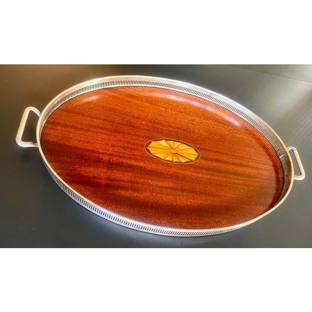 Elegant English style tray with mahogany base framed by a pierced, silver plate gallery. Handles at both ends. Intricate...