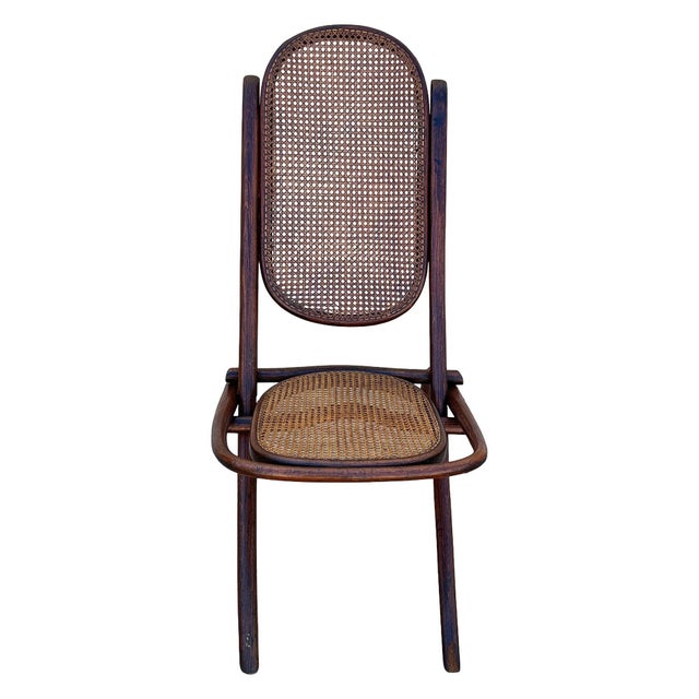 Victorian child-size Thonet number 01 folding chair with woven cane seat and backrest. It features an elegant, sculptural...