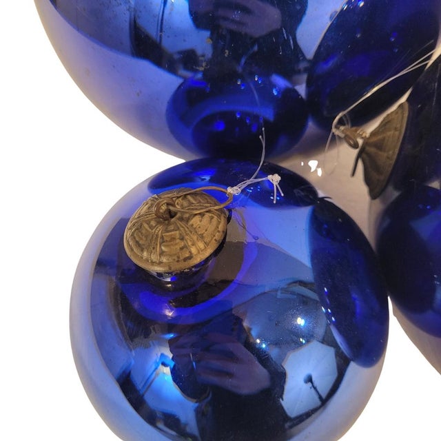 Elegant and original set of four indigo-colored, églomised glass spheres, late 19th century, France. They include a metal...