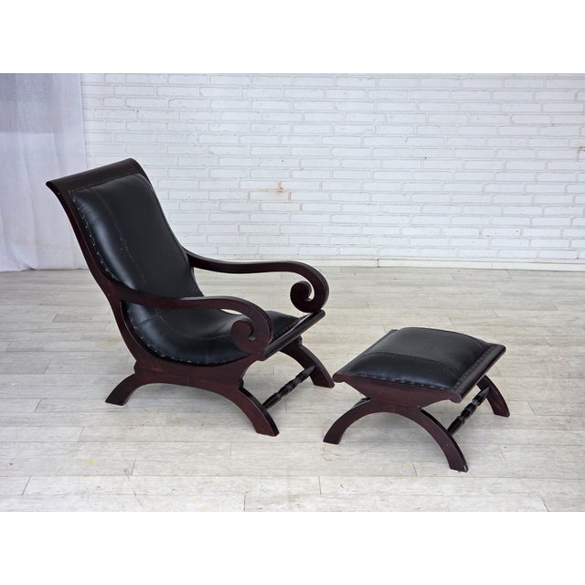 1970s, vintage armchair with footstool. Original black furniture leather, dark burgundy color wood. Original good...