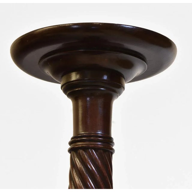 An early 20th century tall Honduran mahogany torchere with spiral turned support, and tripod legs. Circa 1910. The...