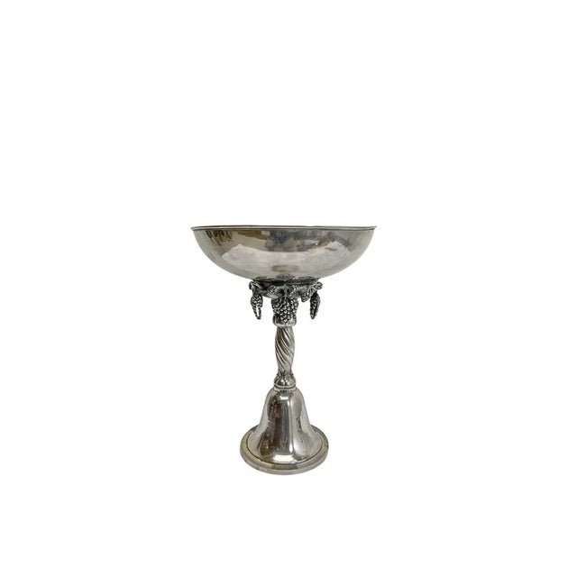 Large, elegant silver-plated fruit bowl on a tall, turned base in the neoclassical style, richly decorated with grape and...
