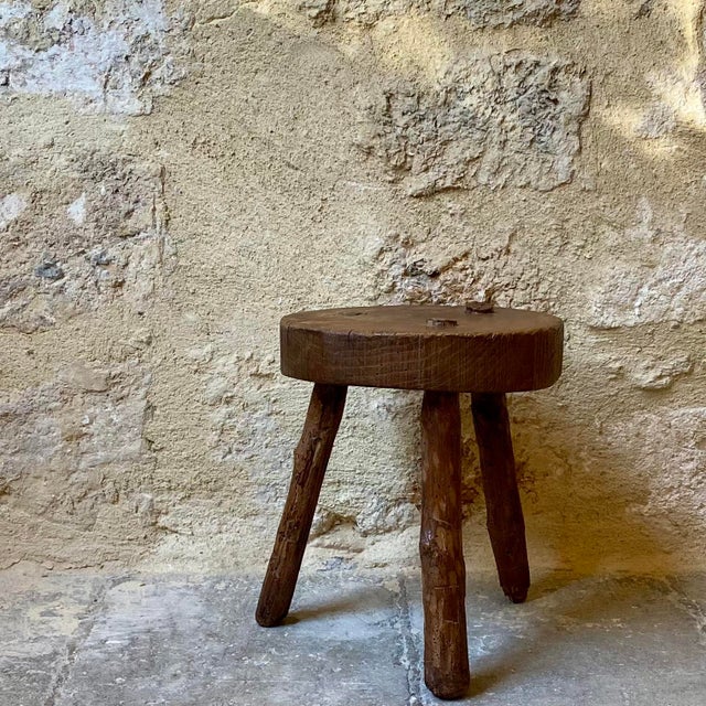 Set of two small tripod stools. One is a semi-circular milking stool, the other a small round stool with turned legs. They...