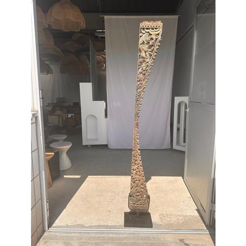 Indonesian construction element in carved wood with intertwined plant motifs mounted on a base. Old traces of red, blue,...