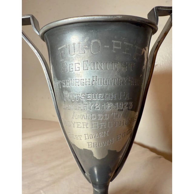 Up for sale is a rare antique silverplate trophy cup from 1923, featuring a unique design with a black wooden stand. It is...