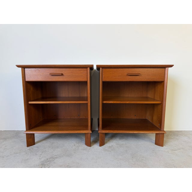 Beautiful pair of vintage Danish Modern teak nightstands featuring a clean minimalist silhouette with warm teak wood grain...