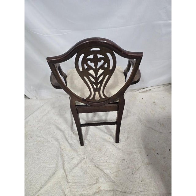 A classic Hepplewhite-style shield back armchair featuring an elegant pierced splat and solid wood construction. This...