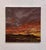 This artwork depicts a dramatic sunset over a rugged landscape, where rich hues of orange and deep red blend seamlessly...