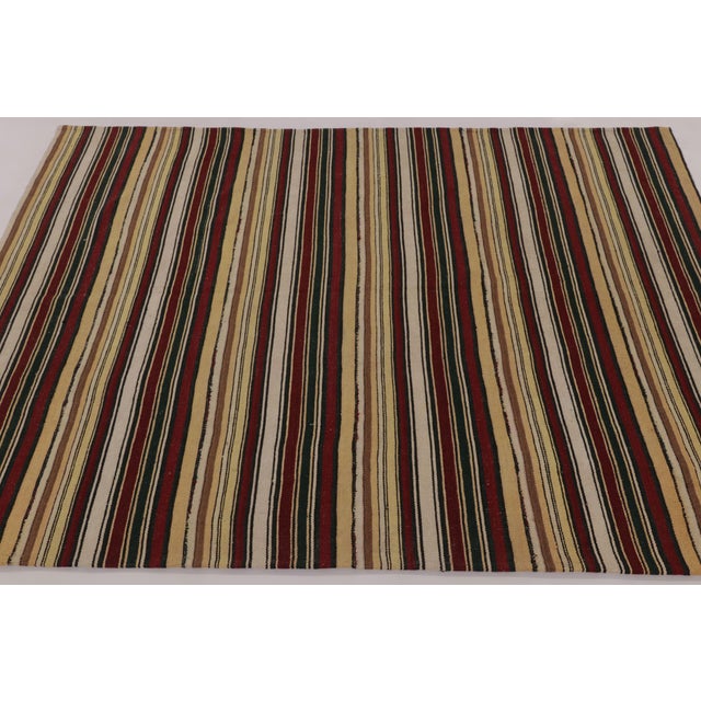 Made with handwoven wool circa 1950-1960, this 5x7 vintage flat-weave Kilim is a particularly cheerful and sought-after...