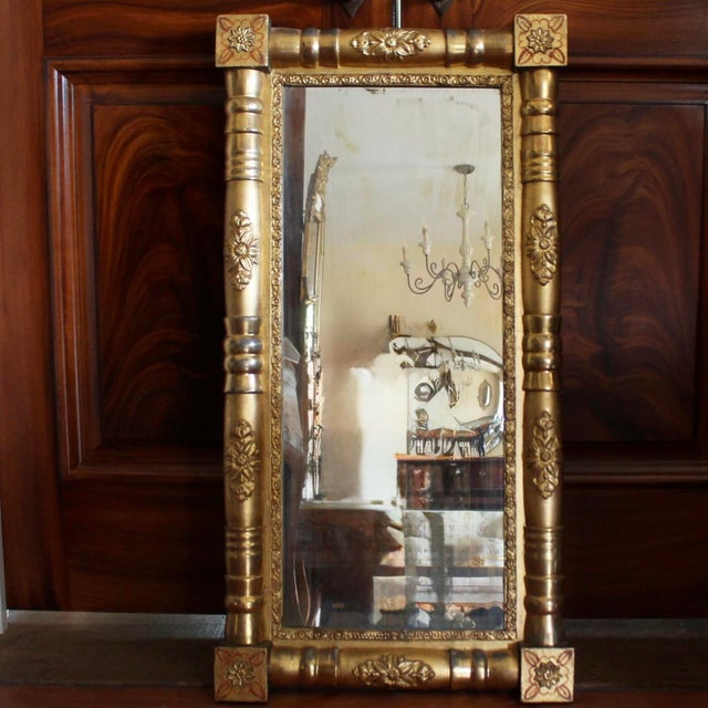 A cheerful giltwood mirror composed of turned elements embellished with applied decorative and dimensional florets. Small...