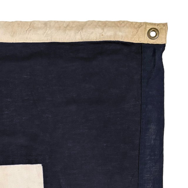 This vintage signal flag has been modified to a different size and shape. Made from a cotton cloth in navy blue and off...