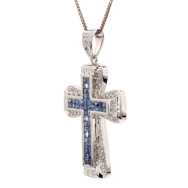 This 18K white gold cross pendant is channel-set with square cut blue sapphires totaling 1.2 carats down the vertical and...