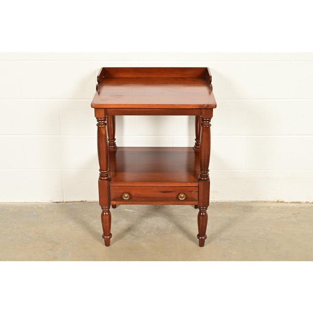 An exceptional American Colonial style bedside table or side table By Davis Cabinet Co. USA, Circa 1960s Carved solid...