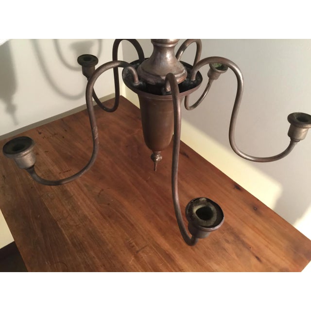 Antique non-electric chandelier designed for use with candles. The piece, which resembles the type of chandeliers that...