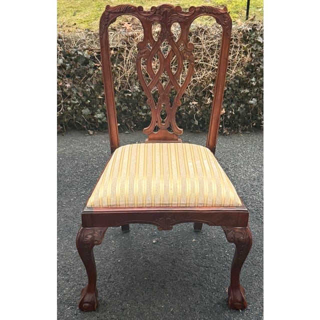 Beautiful pair of Chippendale style dining chairs. Features intricately carved details throughout, upholstered seats and...